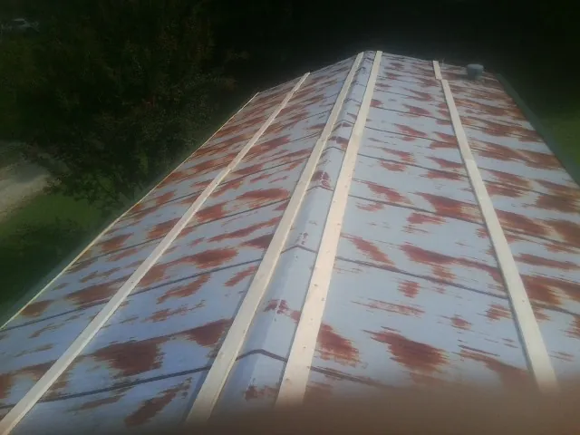 Rusted metal roof panels with new wood purlins before replacement — Storm Damage Roof Repair in Cokeville by Roofing Brothers